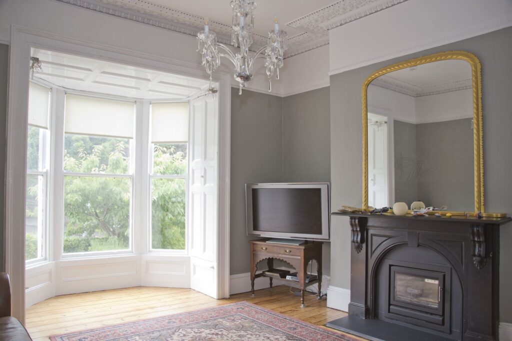 A spacious room with bay windows and a chandelier.